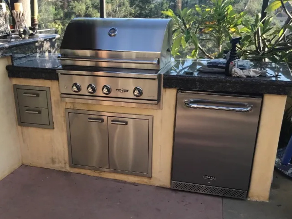 Outdoor kitchen with Bull grill and stainless steel drawers.