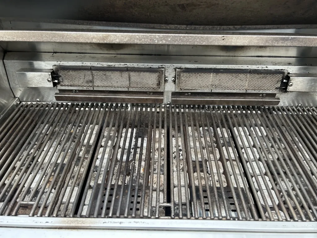 The same jumbo Lynx grill after cleaning, with clean grates over reset briquettes