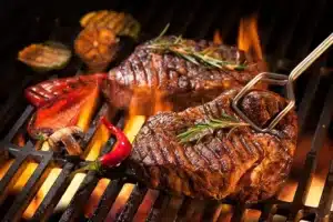 Flame-grilled steaks with vegetables on the grill