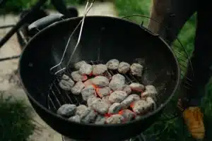 Charcoal briquettes glowing in a round grill
