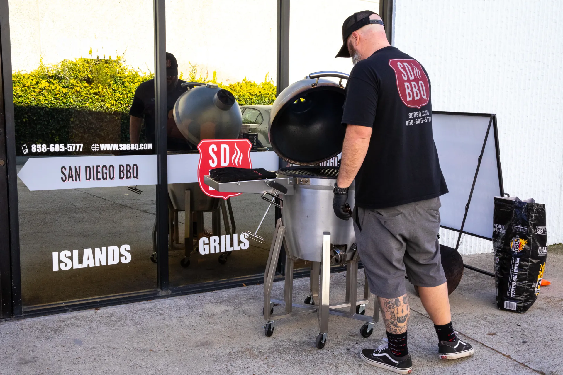 A member of the SDBBQ team cooking on a kamado outside the Carlsbad showroom