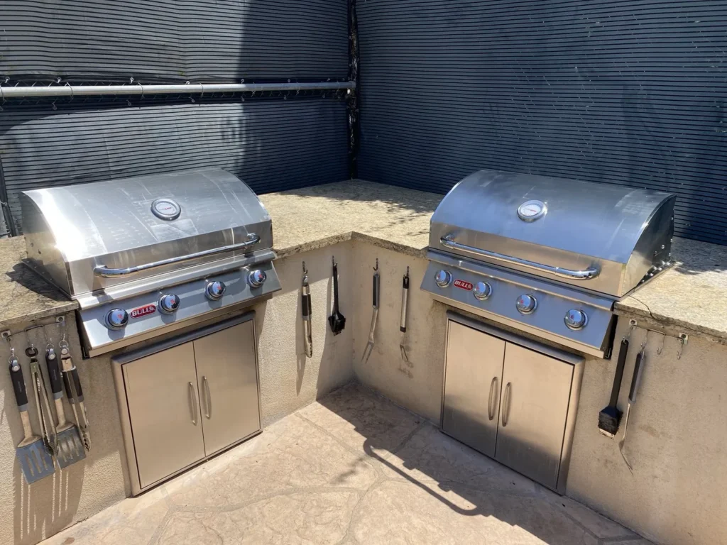 Two new Bull Outlaw built-in grills installed side by side in an L-shaped outdoor kitchen