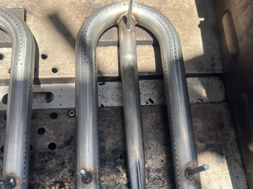 New stainless steel U-shaped burners installed in a cleaned AOG grill