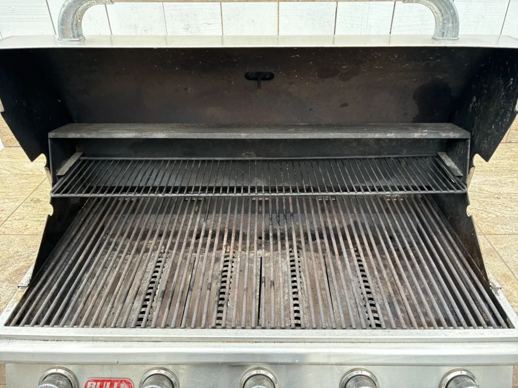 Bull 38-inch gas grill with dirty grates and hood interior before cleaning
