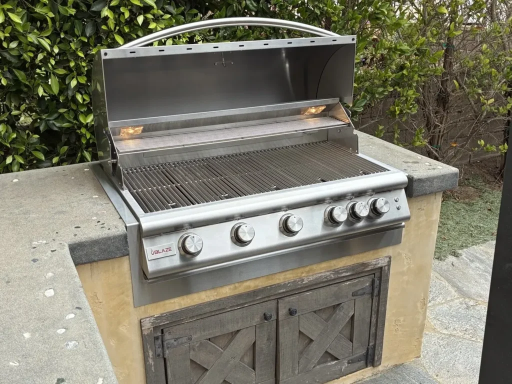 A new 40-inch Blaze built-in grill with its lights on, fitted into an island with a trim kit