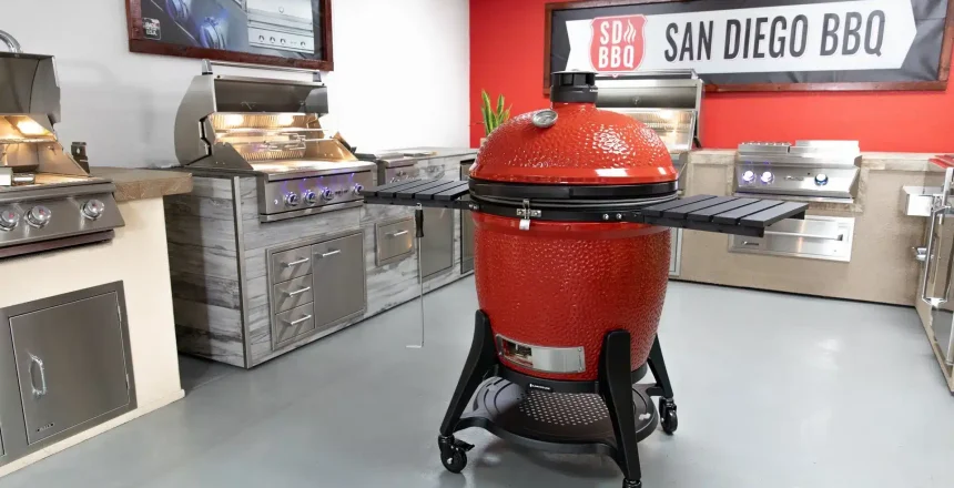 Modern red kamado grill in a showroom with BBQ accessories