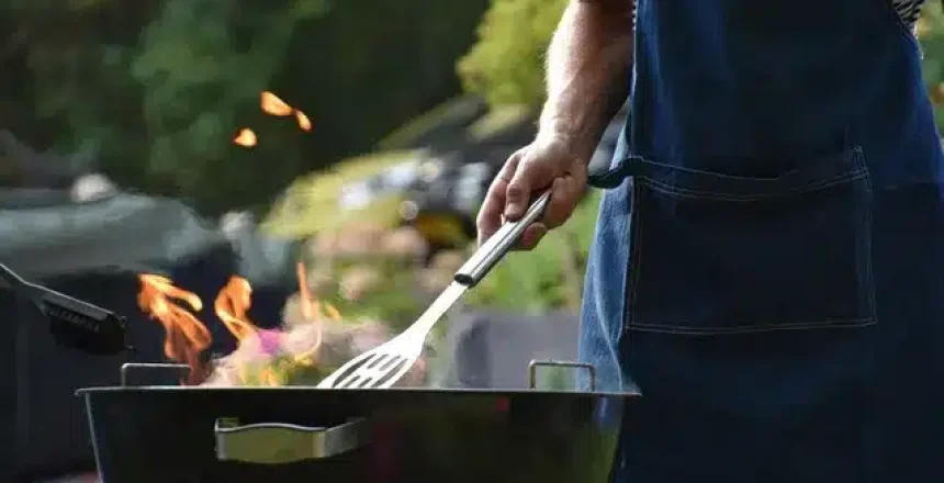 Man cooking on a charcoal grill in backyard
