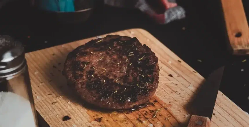 Grilled steak on a wooden board with seasonings